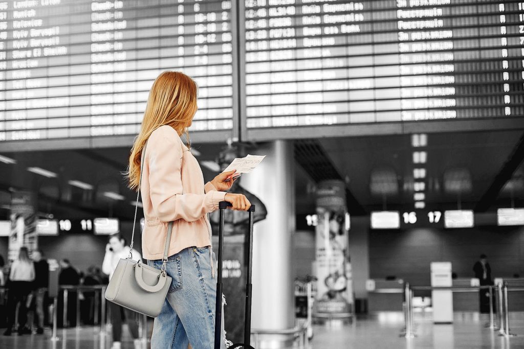 Woman at airport looking at ticket