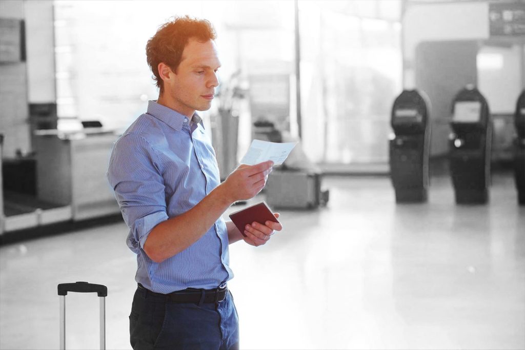 man looking at ticket at airport