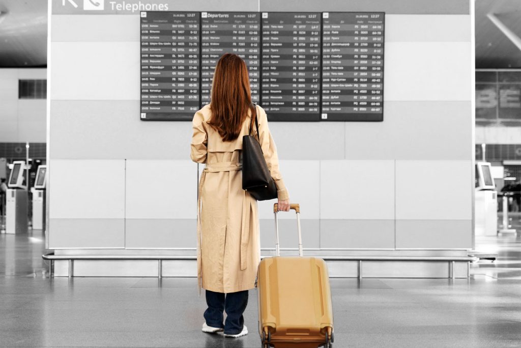 woman looking at airline arrival and departures sign