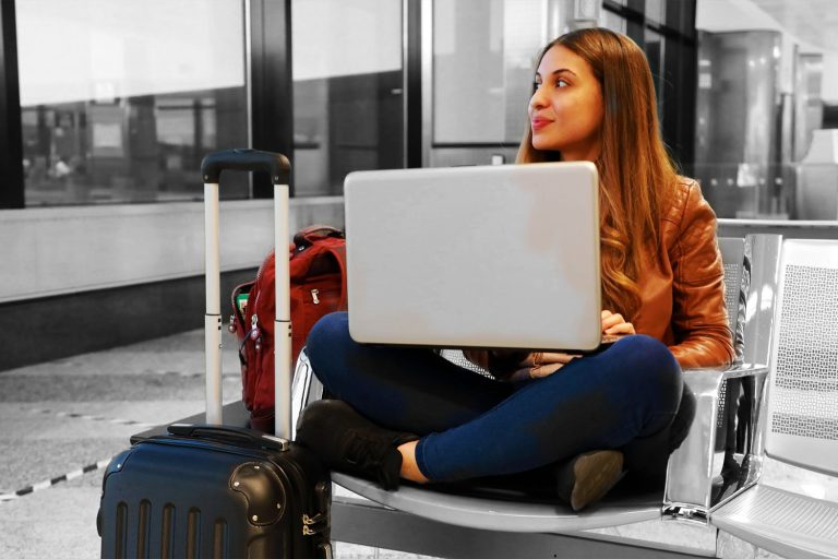 woman sitting at airport using computer