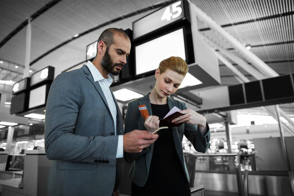 man and woman at airport looking at travel documents