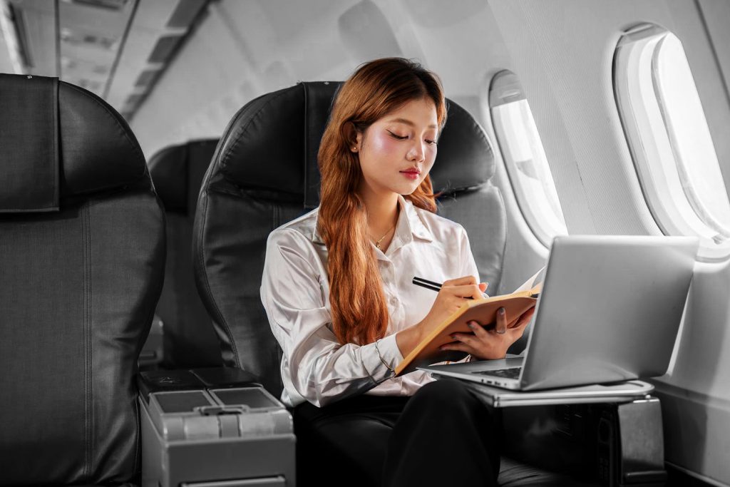 asian woman studying on airplane BW color